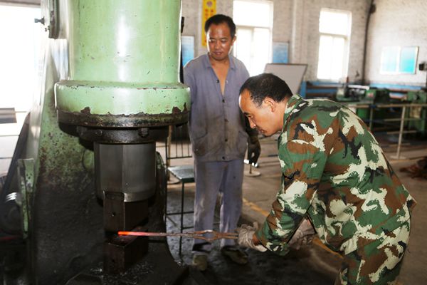 李根生和工友配合在空氣錘前趕工自制件 李根生和工友配合在空氣錘前趕工自制件