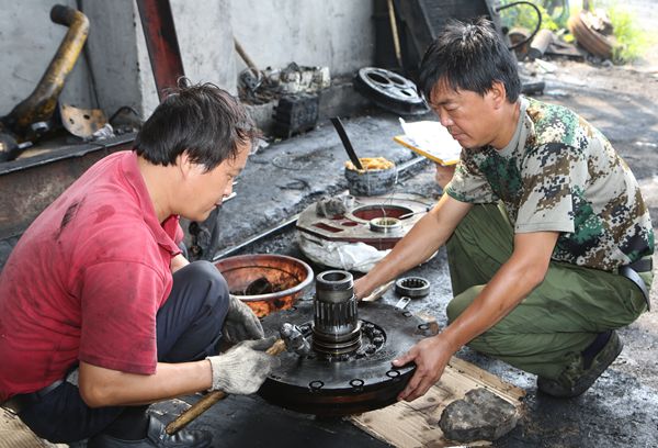 選運區(qū)維修班班長路續(xù)軒和工友對推土機變速箱部件進行整形 選運區(qū)維修班班長路續(xù)軒和工友對推土機變速箱部件進行整形